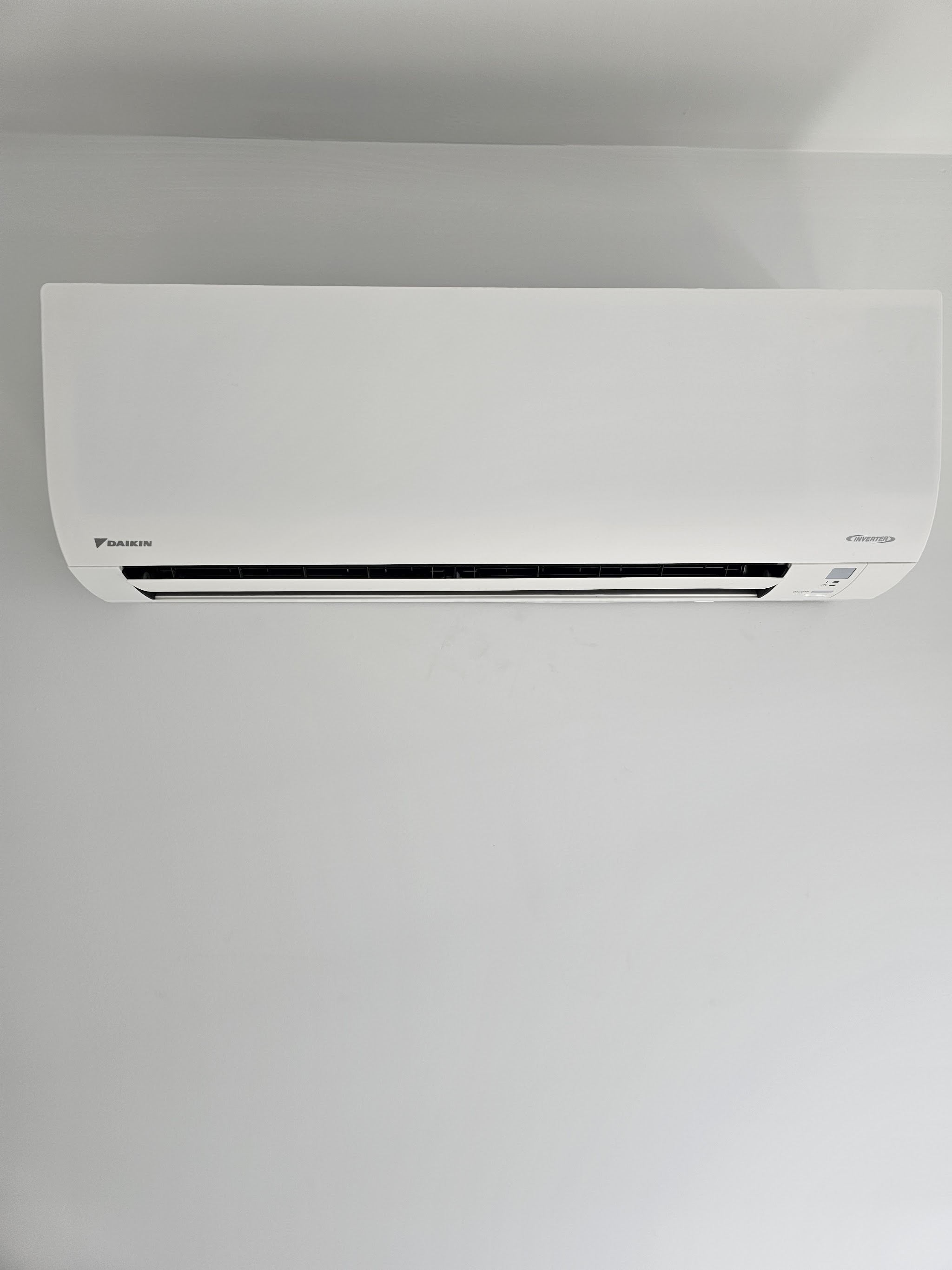 Daikin split system indoor unit mounted on a plain white wall