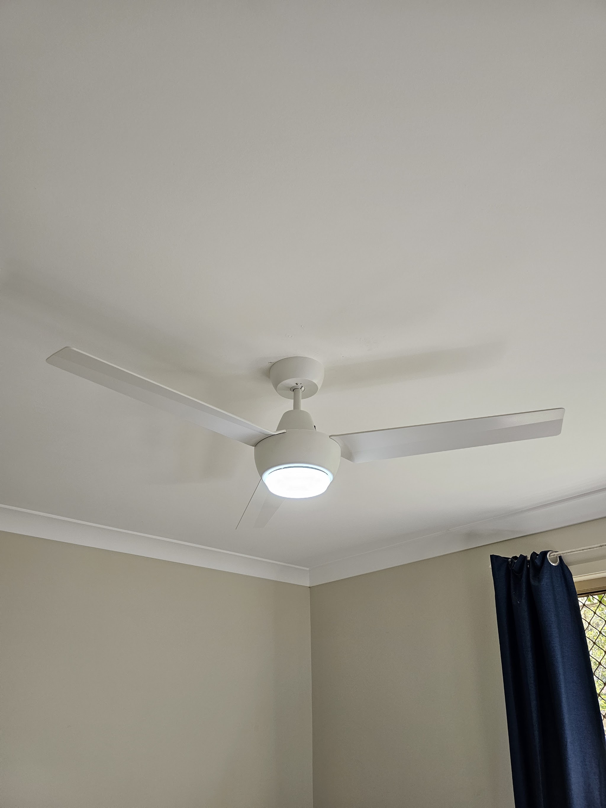 White three-blade ceiling fan with an integrated light, newly installed